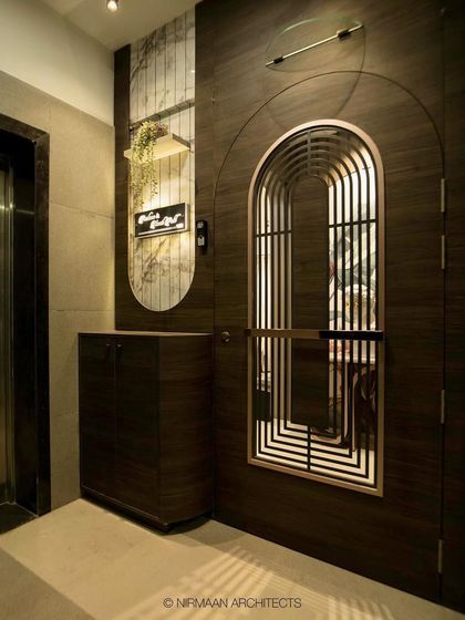 The entrance to this modern classic home features a beautiful arched safety door and a custom console table. The design is elegant, secure, and welcoming.