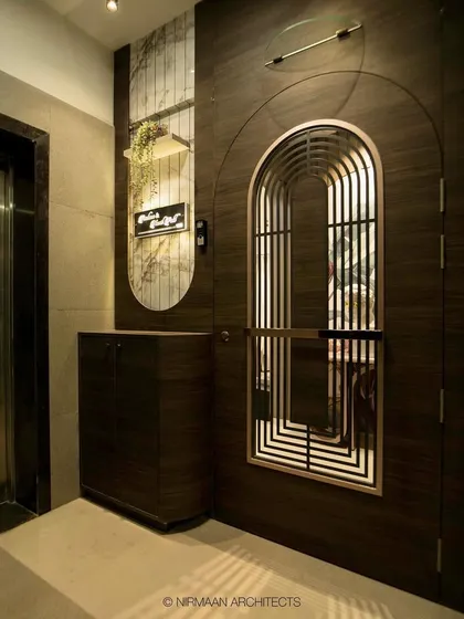 The entrance to this modern classic home features a beautiful arched safety door and a custom console table. The design is elegant, secure, and welcoming.