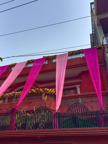 A simple and elegant draping style for a house balcony using two shades of pink.
