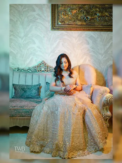 A moment of quiet elegance amidst the celebration. The bride, in her shimmering engagement gown, sits gracefully, looking like a princess.