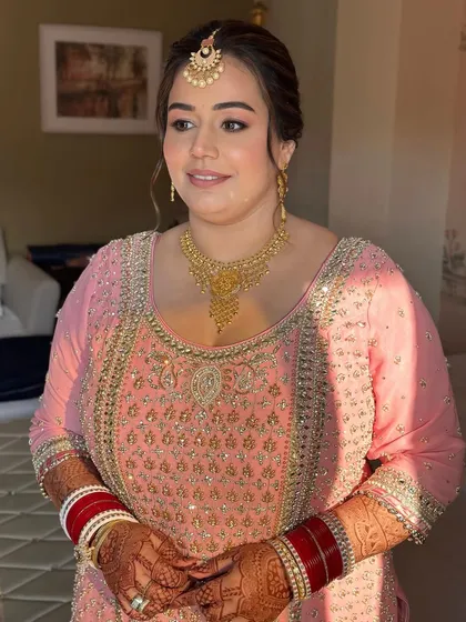 A portrait of elegance. Her makeup is soft, her expression is serene, and she looks every bit the part of a graceful Anand Karaj bride.