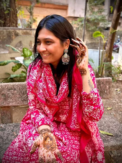A happy photo of me showcasing my personal mehendi design. The artwork features a Shreenathji portrait, combining my passion for henna with my devotion.