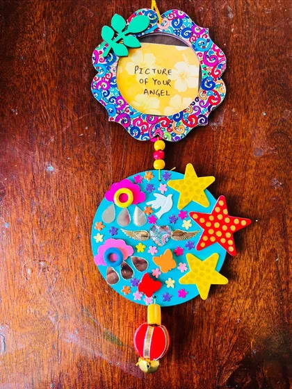 This is my 'Our Angels' custom wall hanging, a piece very close to my heart. It includes a small frame to hold a picture of a loved one. Each element, from the stars to the angel wings, is chosen to celebrate their memory and the love that remains.