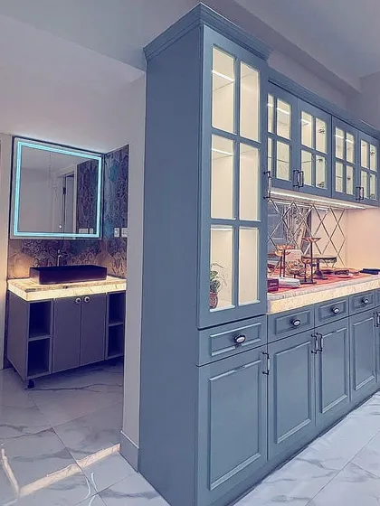 A view of the vanity area from image 11, integrated into a larger space with a matching crockery unit.