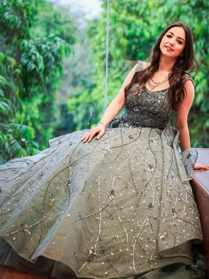 Modeling a beautiful grey embellished gown, perfect for a wedding reception. I focus on creating an aspirational yet approachable look for my audience.