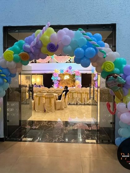 A sweet and colorful candy-themed entrance arch. I used pastel balloons and props like donuts and ice cream cones to welcome guests to this fun birthday party.