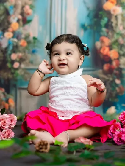 A candid moment where the baby seems to be listening intently, with her hand up to her ear. We love these unscripted shots.