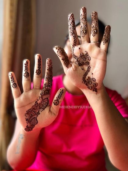 A very modern and minimalist design, with a small Arabic-style pattern on one hand and delicate finger details on the other.