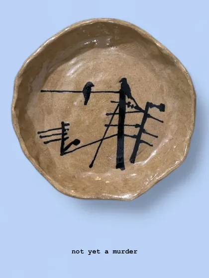'Not Yet a Murder' is a small, hand-formed bowl depicting a common Mumbai scene: two crows on a tangle of wires. It’s a piece of urban-inspired pottery that finds beauty in the everyday chaos.