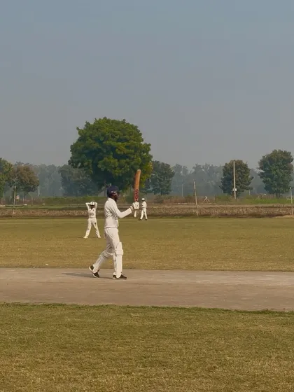 Abhigyan raises his bat to celebrate his fifty.