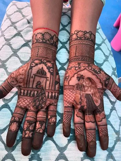 A side-by-side view of the groom's mehendi, with a couple portrait on one hand and a peacock motif on the other.