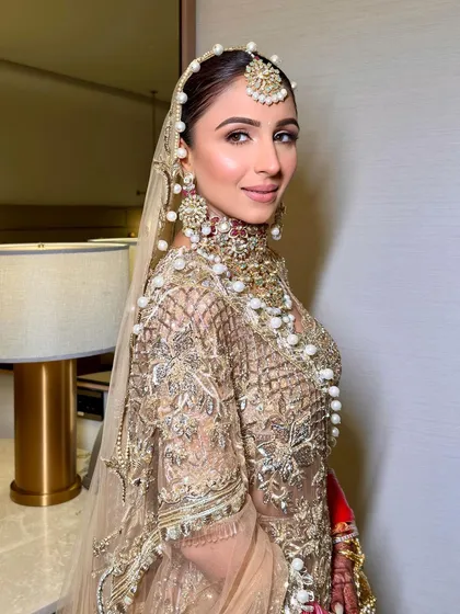 A side profile of Udita's bridal look. The clean hairstyle and soft makeup create a look of timeless elegance.