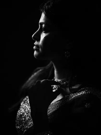 This is an example of our fearless photography approach, using shadow to create drama. This black and white portrait focuses on the bride's profile, with light catching just the edge of her face and the sparkle of her necklace, creating a feeling of quiet intensity.