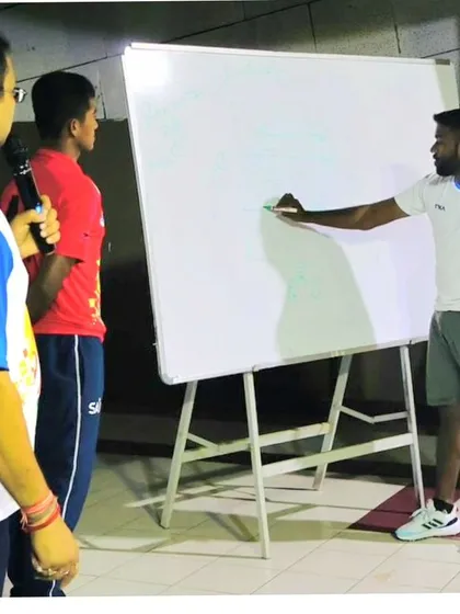 The game is won in the mind before it's won on the field. Here, I am breaking down team tactics on the whiteboard during an athlete education program, ensuring every player understands our strategy.