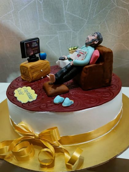 A cake that captures a moment of pure relaxation. This design features a detailed fondant figurine of a man chilling in his armchair, watching TV.