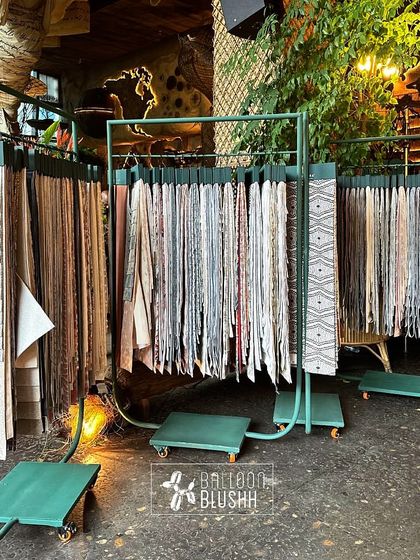 A custom-built display rack for Nesterra's fabric swatches. The functional design allows guests to interact with the products within the context of the overall lush, green theme.