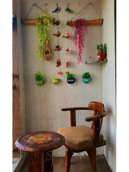 The cozy seating in the balcony corner, perfect for enjoying a cup of tea. The small, carved wooden table and comfortable chair make this a perfect spot to unwind.