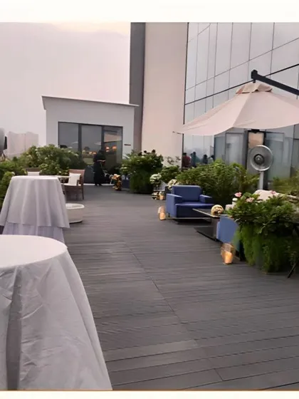 The rooftop venue during setup, showing the spacious deck, cocktail tables, and lounge seating arranged for the evening's event.