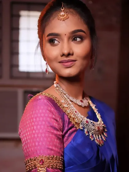 A beautiful reception look with a royal blue saree and diamond jewelry. The makeup is glamorous and modern.