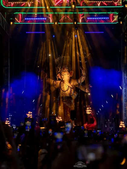 A combination of warm spotlights and cool background lighting creates depth and focus. This photo shows how I balance different lighting elements to highlight the Ganpati idol while illuminating the entire procession route for the crowd.