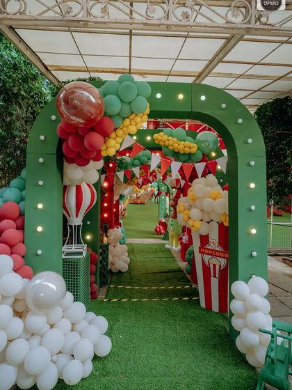 The journey into the party is just as important as the party itself. This grand balloon archway, flanked by popcorn props and lit with festive lights, created an exciting and immersive entrance for Adhyan's carnival birthday.