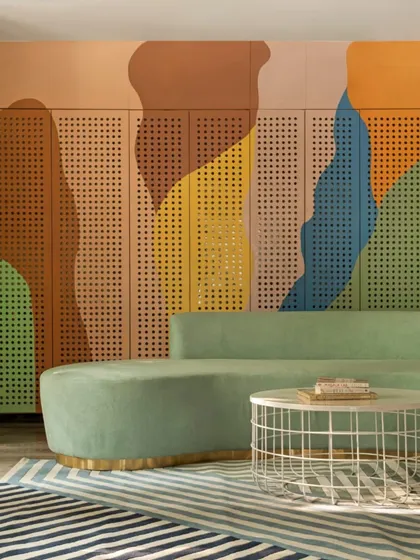 A closer look at the colorful, perforated wall panels and the soft, inviting form of the waiting room sofa. The design uses color, texture, and shape to create a space that feels warm, engaging, and anything but clinical.
