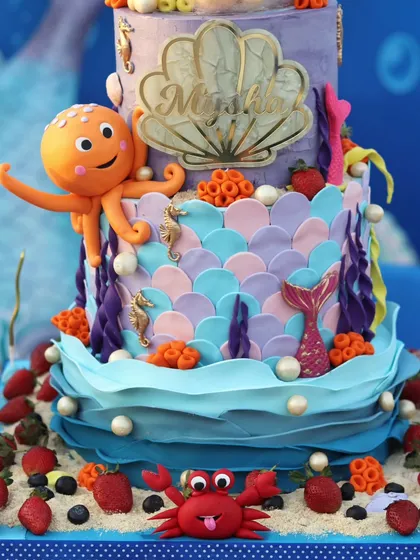 A detailed shot of the lower tiers, featuring a friendly octopus, seahorses, and coral made from fondant.