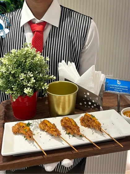Impeccable service is key. Here, my staff presents Coconut Prawns with Mango Salsa on skewers, an easy-to-eat and delicious option for mingling guests at a corporate event.