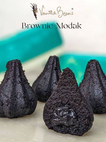Our Brownie Modak is dense, fudgy, and intensely chocolatey, with a gooey brownie batter filling that will satisfy any chocolate craving.