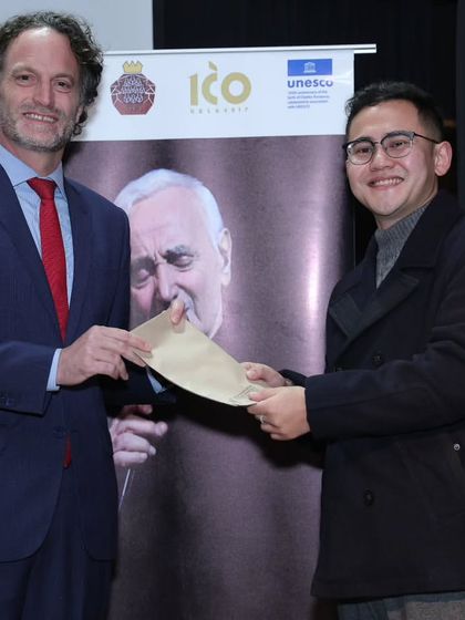 A winner of the singing contest receives his prize from a French diplomat. We celebrate and reward the talented performers who participate in our competitions.