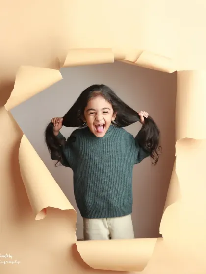 A moment of pure, wild fun. She holds her hair up like a mustache, showing off her silly and playful side.