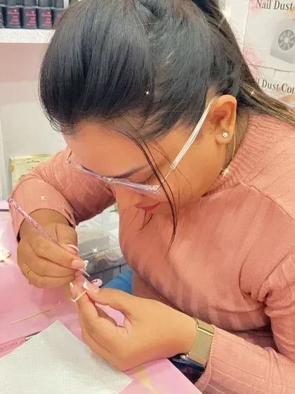 With steady hands, a student applies a bead of acrylic, a crucial moment in creating a flawless nail extension.