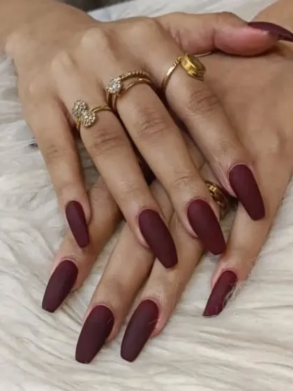 A stunning set of long, matte coffin nails in a deep, rich burgundy. The matte finish gives this bold color a modern and velvety-smooth appearance.