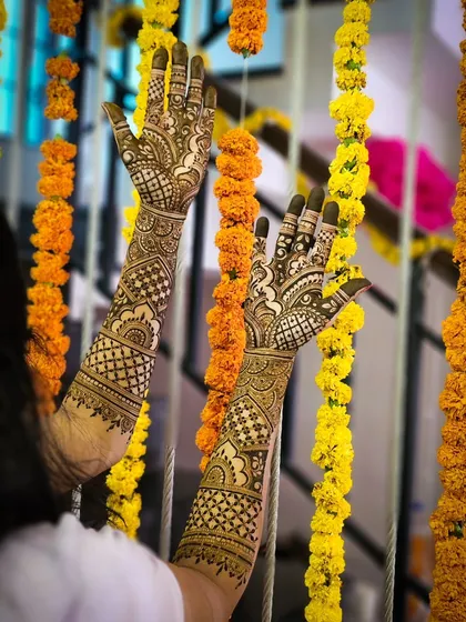 A beautiful shot of bridal henna against a backdrop of marigold flowers.