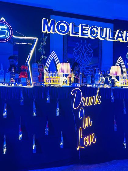 A full view of our futuristic bar setup, featuring a 'Drunk In Love' neon sign, star-shaped stations, and cool blue lighting.