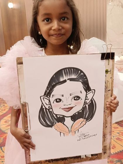 This little girl in her party dress looks adorable next to her caricature.