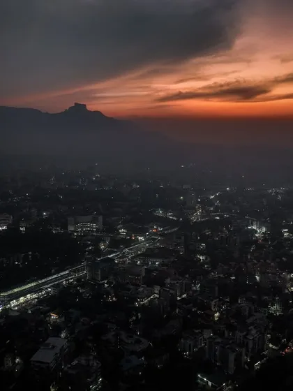 The city of Badlapur under a dramatic sunset sky. The clouds add texture and color to the evening.