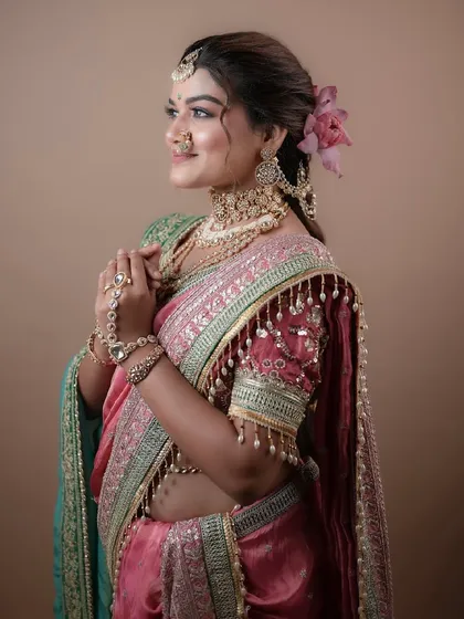 This three-quarter view highlights the intricate jewelry and the soft, elegant makeup that enhances the bride's natural beauty.