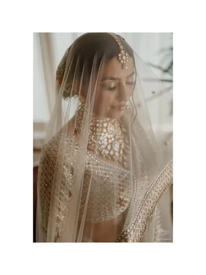 A delicate portrait of the bride under her veil. The soft light and her gentle expression create a timeless and romantic image, capturing her quiet beauty.
