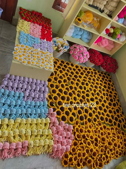 A massive wholesale order laid out, featuring a huge number of sunflowers and colorful rows of amigurumi jellyfish.