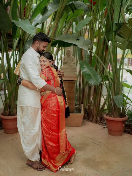 A warm and loving hug amidst lush greenery. This portrait captures the comfort and security the couple finds in each other's arms.