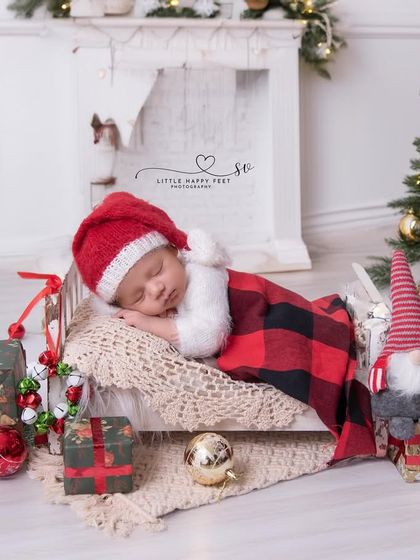 Santa's newest little helper, taking a nap by the Christmas tree. This cozy scene, with a miniature fireplace and presents, is the epitome of holiday warmth.