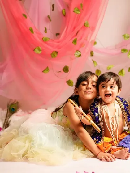 A beautiful moment between siblings dressed as Radha and Krishna. Including older siblings in themed photoshoots creates precious memories of their special bond.