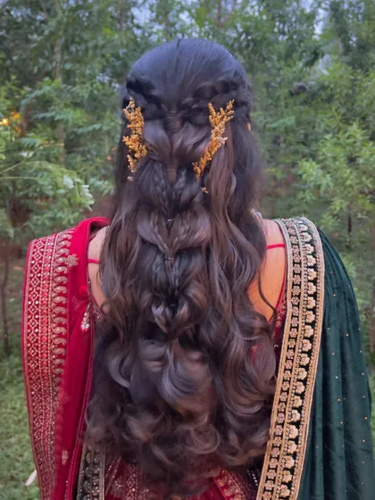 A stunning half-updo with intricate braids and beautiful golden hair accessories.