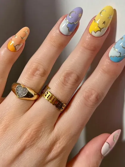 A dreamy, celestial-themed design with a pastel rainbow base, hand-painted clouds, and delicate gold moons and stars.