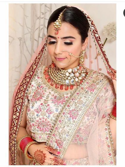This bride opted for a modern floral embroidered lehenga in pastel pink and ivory. The matching oversized Polki and ruby bead jewellery set completes this elegant and contemporary bridal look.