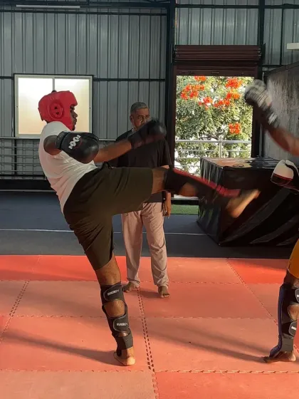 In our MMA classes, we focus on real-world skills and proper technique. Here, I am observing a sparring session, ensuring students apply what they have learned about kicks, blocks, and stances in a controlled environment.