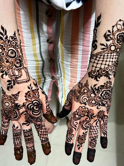 A creative and modern Arabic design that combines florals with geometric netting. The asymmetry between the two hands adds a contemporary and artistic flair.