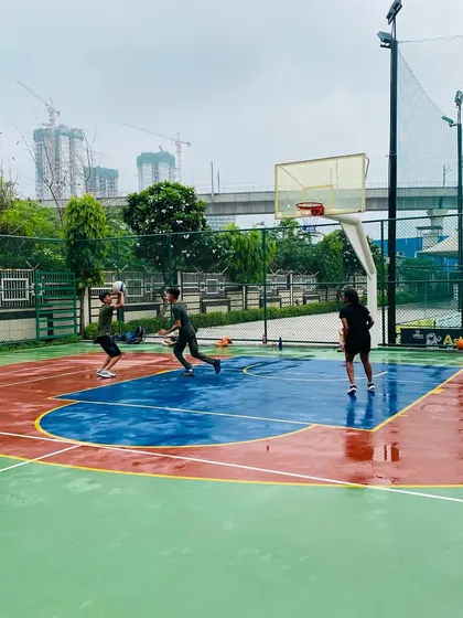 A female player practices her dribbling on a wet court.