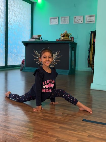 The proud smile of accomplishment. This student nails her center split, showcasing the results of her consistent effort and our structured flexibility training.